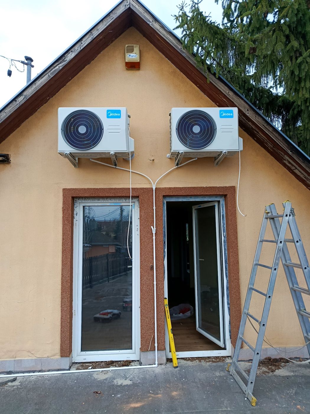 Két Midea kültéri egység szimmetrikusan egy családi ház oromfalán