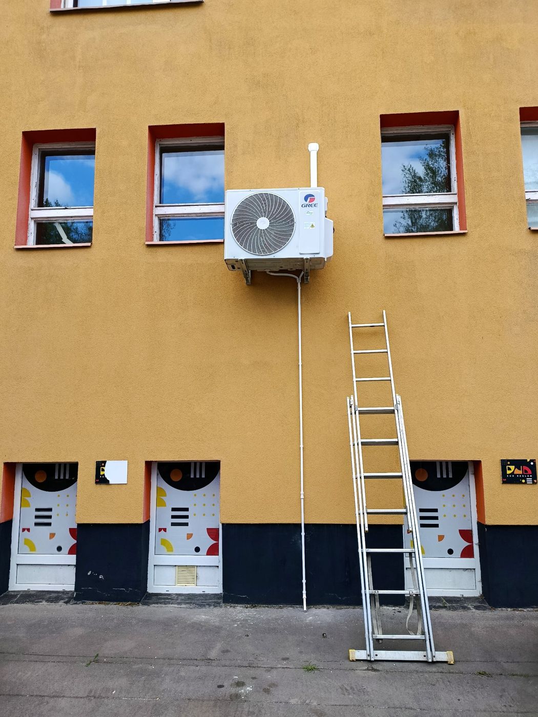 Gree kültéri egység magasan a homlokzaton, létrával